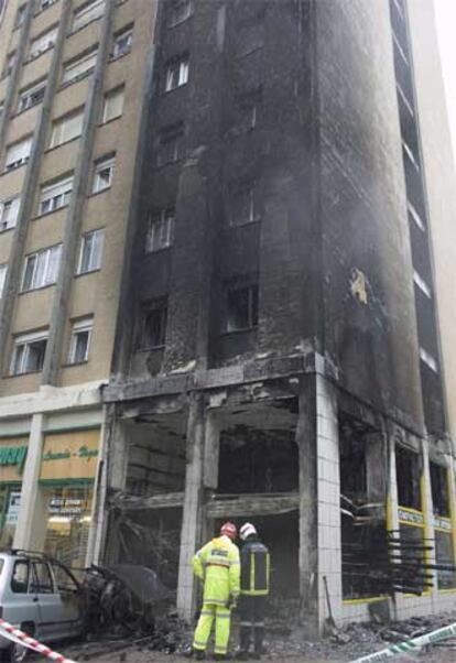 Varios bomberos trabajan en las tareas de desescombro en la ferretería de un edil de UPN de Barañain destrozada por un incendio intencionado.