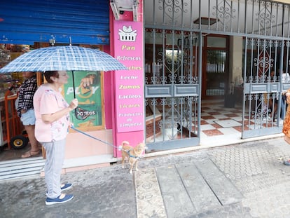 Vecinos de Sevilla caminan frente al portal de la vivienda donde han ocurrido los hechos. EFE/ JOSÉ MANUEL VIDA