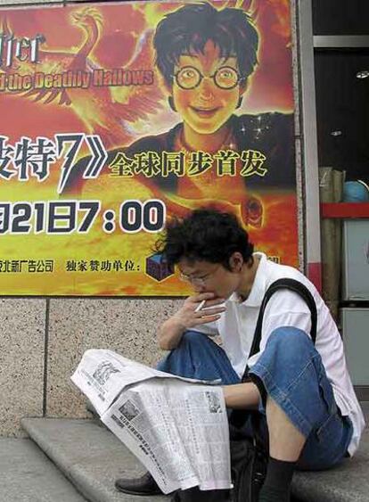 Un joven lee ante un cartel de promoción de Harry Potter en Pekín.