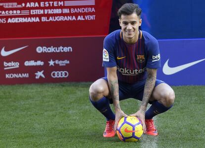 El nuevo centrocampista brasileño Philippe Coutinho posa con su nueva camiseta durante su presentación oficial en Barcelona.