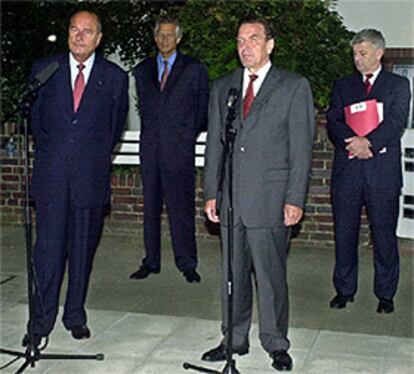 Chirac y Schröder hablan con la prensa ante la mirada de sus ministros de Exteriores, De Villepin y Fischer.