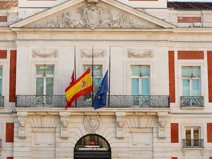 Las banderas madrileña, española y de la UE ondean a media asta en la fachada de la Real Casa de Correos, sede del Gobierno regional.