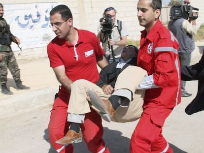 Miembros de la Media Luna Roja trasladan a un ciudadano durante una operaci&oacute;n de evacuaci&oacute;n en Muadamiya, una zona rural de Damasco. 