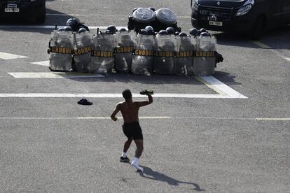 Un hombre lanza una zapatilla contra policías de la Tropa de Choque en Rio.