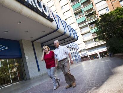 Núria Manzanares i Enrique Vicente, els pares que van perdre dos fills, passen per davant de l'entrada d'Hipercor.