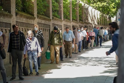 Personas esperando a recibir comida en el Comedor Social de las Hijas de la Caridad de Madrid