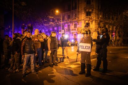 El diputado ultra, a la derecha con los brazos cruzados, frente a varios antidisturbios, anoche en la calle de Ferraz de Madrid.