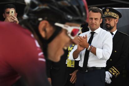 El presidente francés, Emmanuel Macron, aplaude la llegada de los ciclistas a la línea de meta.