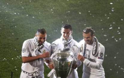 Benzema, Cristiano Ronaldo y Bale, sujetan la Copa de Europa ganada por el equipo blanco.