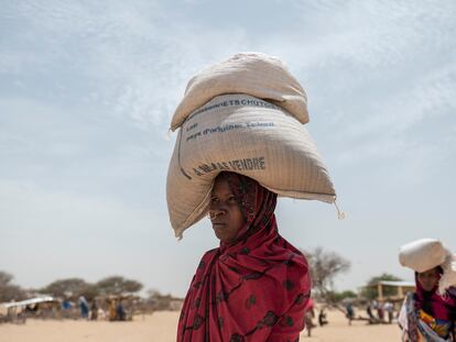 Asetta Noor transporta dos sacos de granos de una distribución de alimentos realizada por el Programa Mundial de Alimentos, en el campamento de refugiados de Fourkoulom en Baga Sola, Chad, el 11 de mayo de 2022.