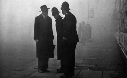 Un hombre habla con dos policías en un puente de Knightsbridge en imagen de los años 50.