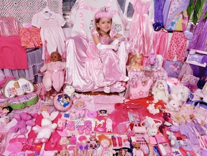 Menina mostra seus brinquedos cor-de-rosa.