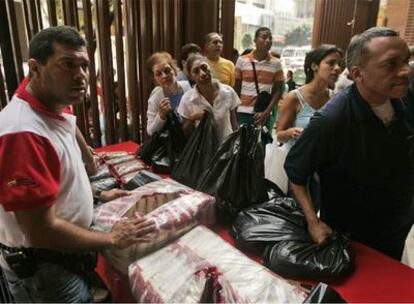 Vecinos de Caracas hacen cola para comprar arroz en un mercado estatal.
