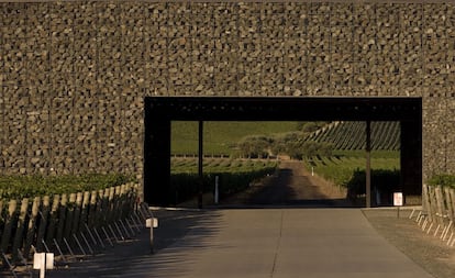 Las fachadas de los tres edificios que componen la bodega están revestidas con gaviones, redes metálicas rellenas de piedras que aislan del calor diurno y el frío nocturno. "Elegimos piedra basáltica de la zona cuyos colores van del verde oscuro al negro y se mimetiza a la perfección con el paisaje. Los gaviones se llenan más o menos (...) para que la luz natural entre en las estancias durante el día y la luz artificial se filtre al exterior a través de las piedras de noche", dice la memoria del proyecto.