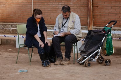 Un voluntario de Psicólogas y Psicólogos Sin Fronteras junto a una ciudadana en un instituto de la localidad valenciana de Sedaví, convertido en un centro de Atención Ciudadana.
