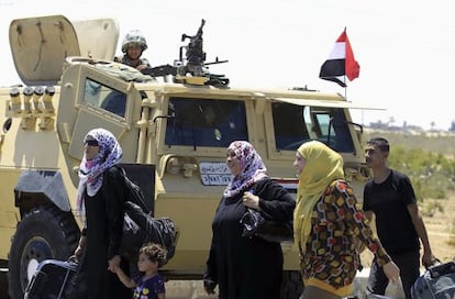 Varios palestinos de regreso Gaza pasan ante un tanque egipcio en el paso de Rafah el viernes.