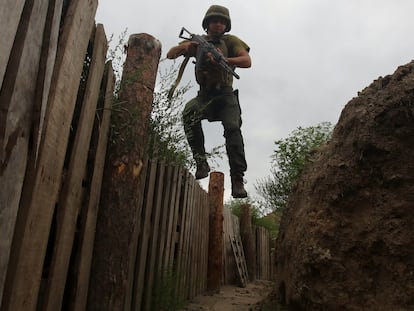 A member of the Ukrainian National Guard jumps into a trench at a position near a front line, as Russia's attack on Ukraine continues, in Kharkiv region, Ukraine August 3, 2022. REUTERS/Vyacheslav Madiyevskyy
