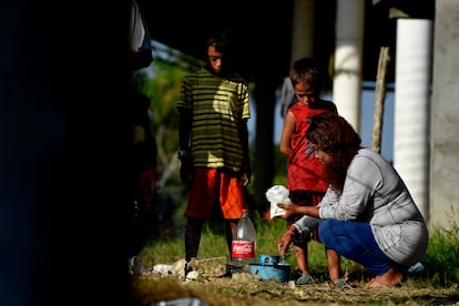 Una mujer de la caravana de migrantes con destino a Estados Unidos cocina en presencia de unos niños en Palo Dulce, estado de Veracruz, México, el 17 de noviembre de 2021.