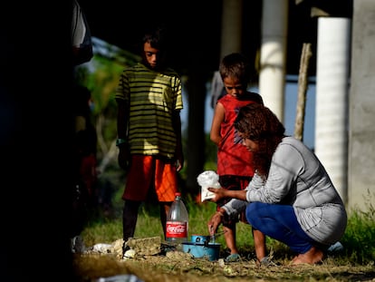 Una mujer de la caravana de migrantes con destino a Estados Unidos cocina en presencia de unos niños en Palo Dulce, estado de Veracruz, México, el 17 de noviembre de 2021.