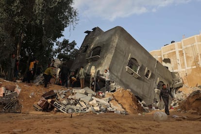 Un grupo de personas buscan entre los escombros de una casa destruida por un ataque israelí sobre Rafah, este domingo. 