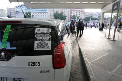 Los taxistas de todo el país exigen al Gobierno el cumplimiento de la ley. En la imagen, un taxi con uno de los carteles de la huelga, en Atocha.