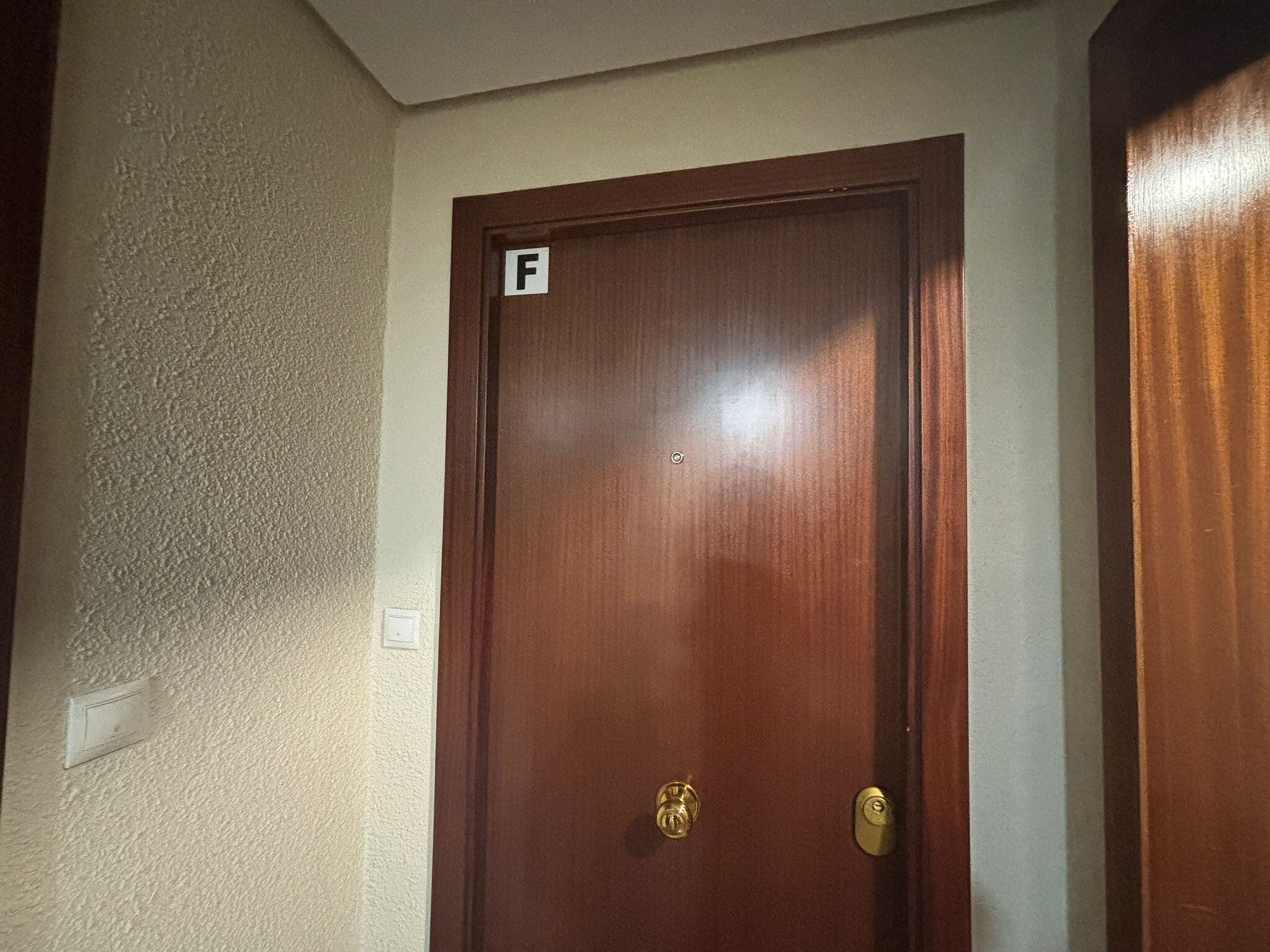 La puerta del piso donde ha sido asesinada una mujer de 49 años por su hijo esta madrugada en Madrid.