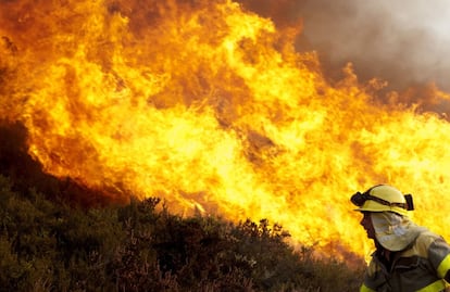 Un bombero, durante las labores de extinción del incendio declarado en la localidad orensana de Santirso.