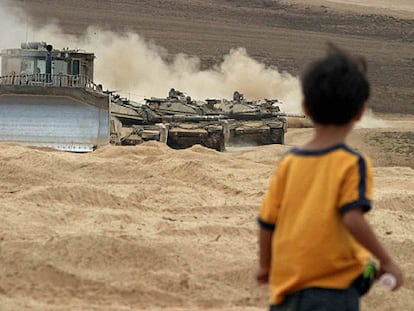 Un niño palestino observa los tanques israelíes en las cercanías del campo de refugiados de Yabalia, en la Franja de Gaza.