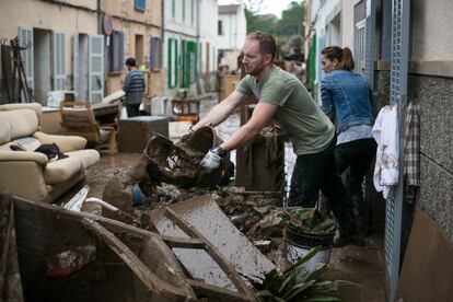 Vecinos de Sant Llorenç des Cardassar limpian sus casas y sus calles tras la tromba de agua que inundó la localidad mallorquina el 10 de octubre de 2018 y que causó 13 muertos.