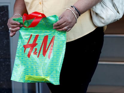 FILE PHOTO: A woman holds an H&M bag after shopping at an H&M clothing store in Hollywood, California January 26, 2011. REUTERS/Fred Prouser/File Photo