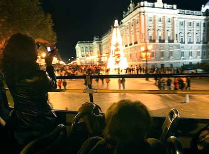 Pasajeros del servicio especial de Navidad contemplan el Palacio de Oriente.