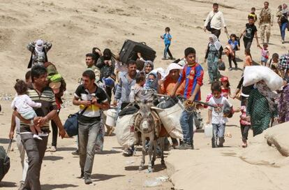 Refugiados sirios cruzan a Irak desde Dahuk.
