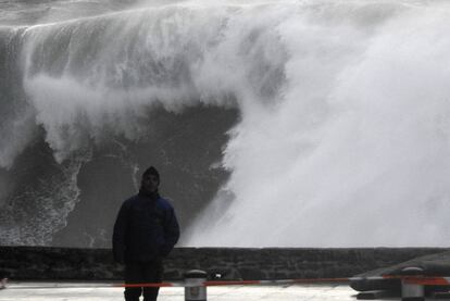 Un hombre camina cerca de las olas esta tarde en la costa de Muxía (A Coruña).