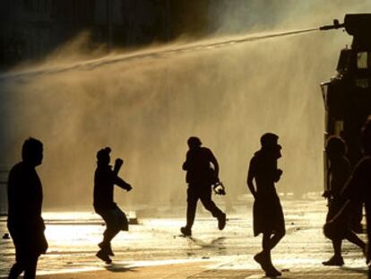 Un vehículo policial lanza agua para dispersar a los oponentes a Pinochet en la noche del domingo en Santiago, cerca del palacio de La Moneda.