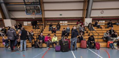 Varios pasajeros descansan en un polideportivo en Zaventem, cerca de Bruselas (Bélgica), tras ser evacuados del aeropuerto de Bruselas tras los atentados.