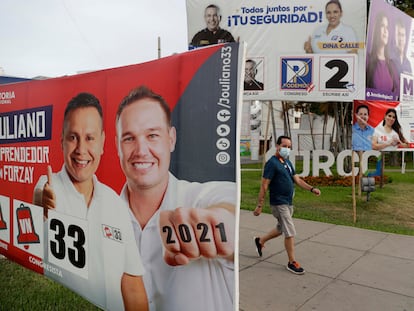 Un hombre camina frente a varios carteles electorales el pasado 15 de marzo en Lima (Perú).