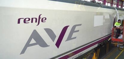 Trabajos de rotulación sobre un tren de alta velocidad con el nuevo logotipo del AVE de Renfe.