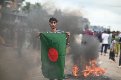 Un manifestante muestra la bandera de Bangladés durante las protestas, este lunes, en Barishal.
