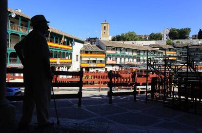 Un vecino en la plaza Mayor de Chinchón, adornada con banderas de España.