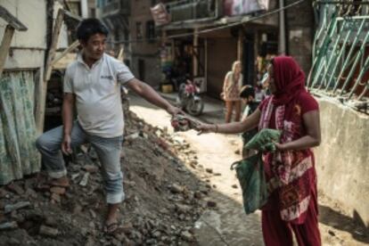 Tika y Ramesh removiendo los escombros de su vivienda en ruinas. Tika y sus hijos fueron rescatados por su marido Ramesh y un vecino, solo recuerda el estruendo de la caída de su casa y la llegada al hospital.