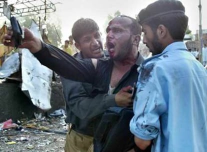 Un policía es auxiliado por dos compañeros tras resultar herido en el atentado ocurrido en Islamabad.