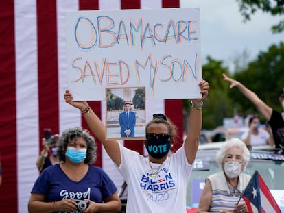 Una persona sostiene una pancarta en la que se lee "Obamacare salvó a mi hijo" en un evento de campaña de Joe Biden en Miami en 2020.