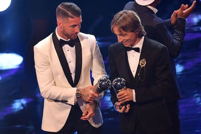 Los jugadores del Real Madrid, Sergio Ramos y Luka Modric, chocan sus trofeos que les acreditan como parte del mejor once mundial según la FIFA.