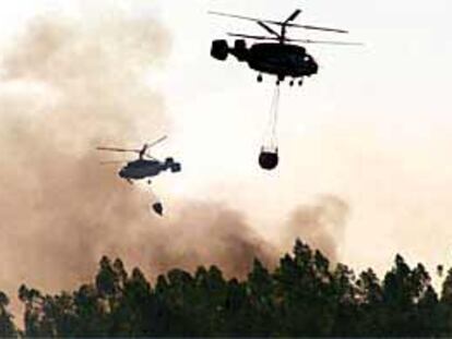 Equipos del servicio aéreo contra incendios de la Junta trabajaban ayer en la extinción del fuego registrado en la sierra de Huelva.