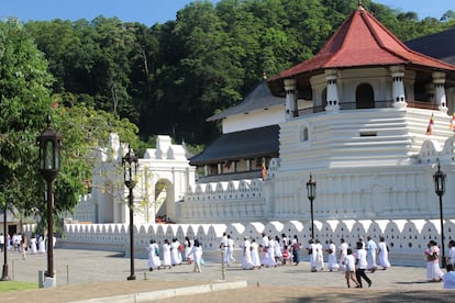 Peregrinos vestidos de blanco en el templo del Diente Sagrado de Buda.