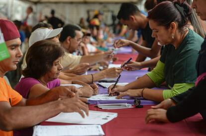 Um grupo de pessoas se prepara para votar em Caracas (Venezuela).