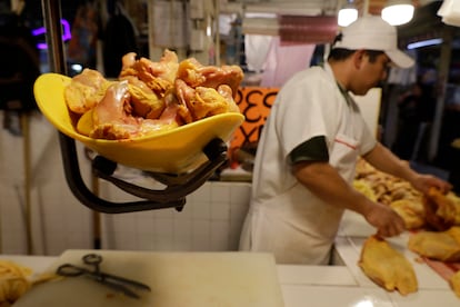 Un hombre pesa piezas de pollo en un mercado en Ciudad de México, en marzo de 2024. 