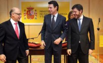 Los ministros de Hacienda, Cristóbal Montoro y de Industria, José Manuel Soria, con el secretario de Estado de Energía, Alberto Nadal, en el acto de toma de posesión del cargo de este último.