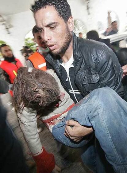 Un médico lleva en brazos a una niña palestina herida en la ciudad de Gaza por el bombardeo israelí.