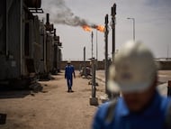 FILE - Workers walk in the Zubair oil field, whose operations have being reduced since the start of the Iran war, near Basra, Iraq, March 28, 2026. (AP Photo/Leo Correa, File)